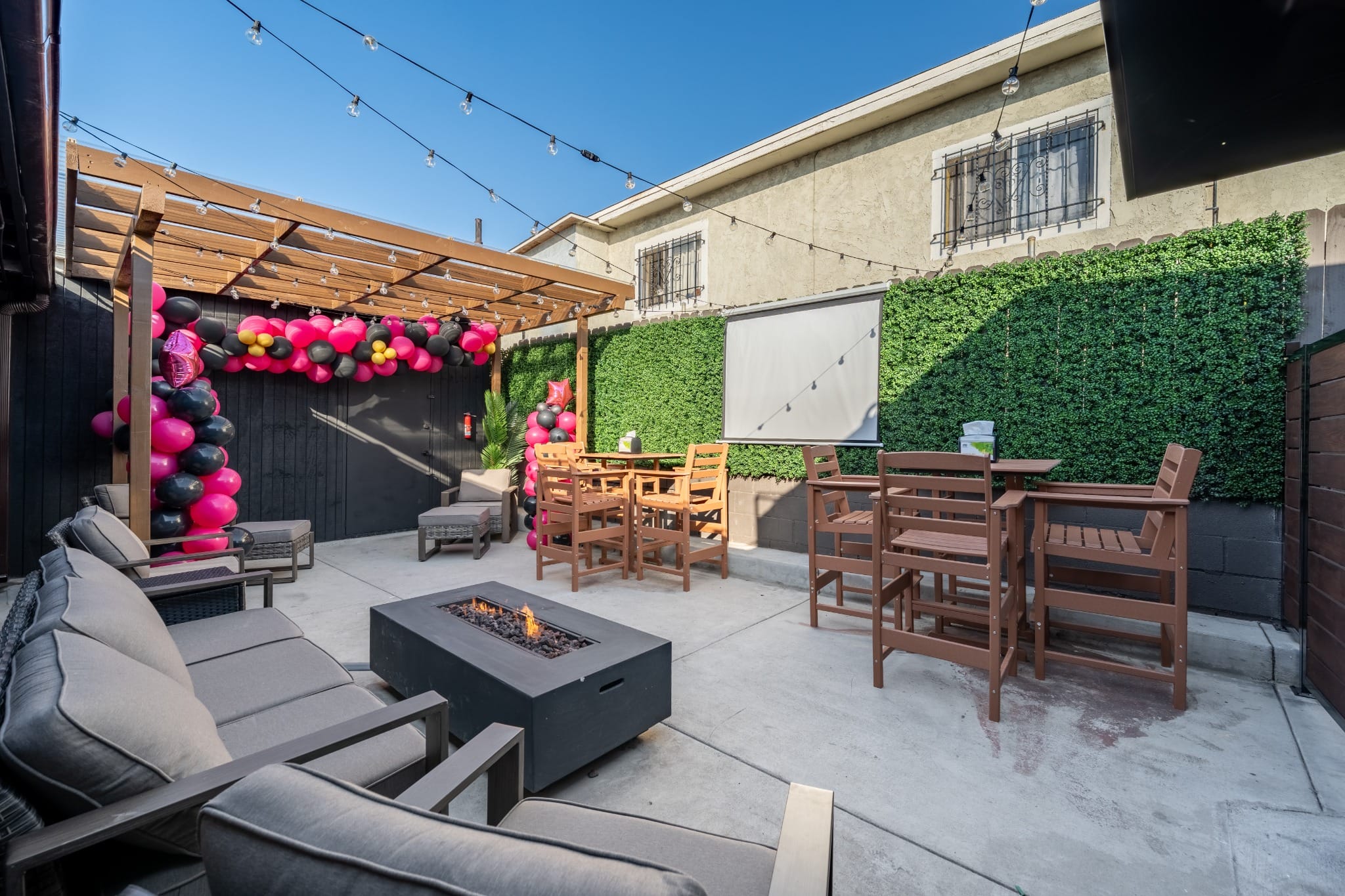 Sunlit patio decorated with pink and black balloons for the grand opening